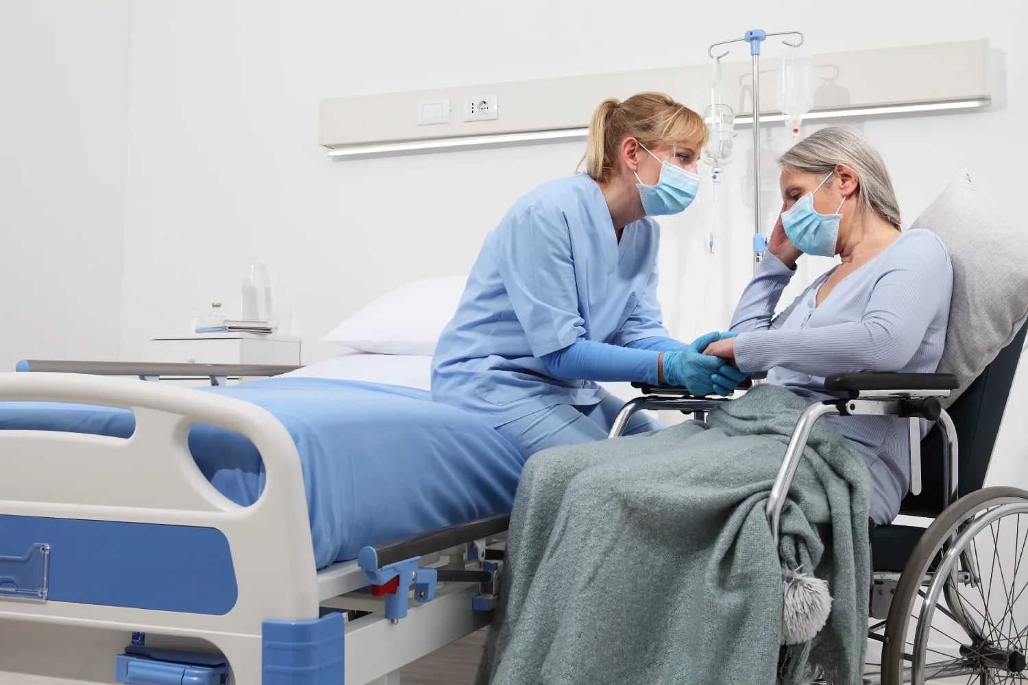 nurse take comfort elderly woman in wheelchair wearing surgical protective medical masks in hospital room, concept of isolation from corona virus covid 19
